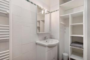 a white bathroom with a sink and shelves at Gîte la maison du sabotier in Saint-Malo-du-Bois +28 photos
