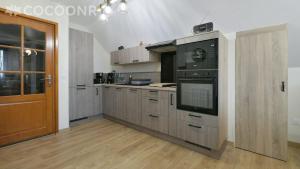 a kitchen with a black oven and wooden cabinets at Gîte du Pont d 'Amourette in Mayenne