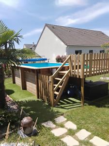 a wooden deck and a swimming pool in a yard at Gîte du Pont d 'Amourette in Mayenne