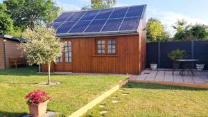 a small house with solar panels on the roof at Gîte du Pont d 'Amourette in Mayenne