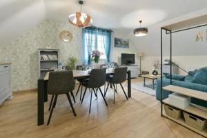 a dining room and living room with a table and chairs at Gîte du Pont d 'Amourette in Mayenne