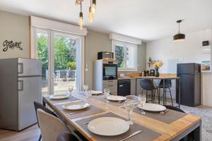 a dining room with a table and chairs and a kitchen at Gîte la maison du sabotier in Saint-Malo-du-Bois