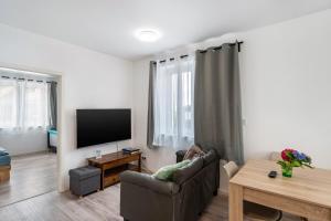 a living room with a couch and a flat screen tv at Haus Seeluft - W1 in Butjadingen