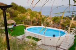 a swimming pool with a boat in a yard at Tenuta Bellassai in SantʼAlessio Siculo