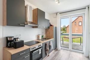 a kitchen with a sink and a stove top oven at Haus Seeluft - W1 in Butjadingen