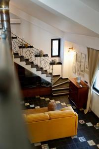 a living room with a couch and a staircase at Tenuta Bellassai in SantʼAlessio Siculo