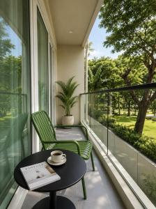 a balcony with a table and chairs and a window at Syama Mansion Kamala in Kamala Beach
