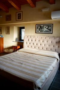a bedroom with a large bed with a tufted headboard at Tenuta Bellassai in SantʼAlessio Siculo +59 photos