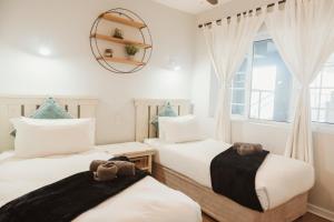two beds in a room with a mirror on the wall at Wildecrest & Ripplemead, Amblewood Guesthouse in Kenton on Sea +45 photos