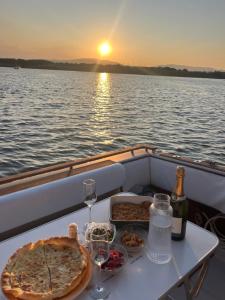 a table with a pizza and wine glasses on a boat at Sunset boat in Leucate-Plage