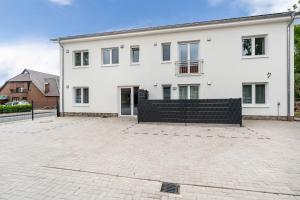a white house with a large driveway at Haus Seeluft - W3 in Butjadingen