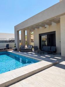 a house with a swimming pool and a patio at וילת צאלים in Yeroẖam