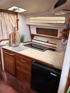a kitchen with a sink and a stove in an rv at Sunset boat in Leucate-Plage