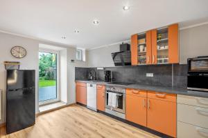 a kitchen with orange and gray cabinets and a window at Ferienhaus Nala Görlitz in Görlitz