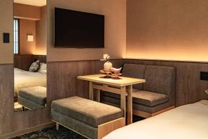a hotel room with a table and a tv at Apartment Hotel 11 Gion in Kyoto
