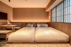 a bedroom with two beds and a window at Apartment Hotel 11 Gion in Kyoto +10 photos