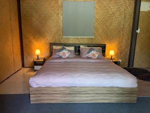 a bedroom with a large bed with two lamps at Alisa Villa, Ubon Cottage in Ban Pla Duk