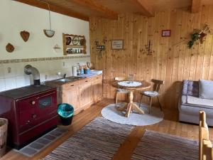 a kitchen with a stove and a table and a couch at Jakobihütte in Sankt Margarethen bei Knittelfeld