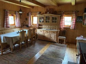 a kitchen with a table and chairs in a cabin at Jakobihütte in Sankt Margarethen bei Knittelfeld +28 photos