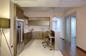 a kitchen with a desk and a chair in it at Heykel Suites Otel in Konak