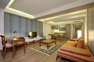 a living room with a couch and a table at Heykel Suites Otel in Konak