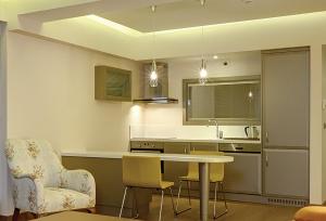 a kitchen with a table and chairs and a sink at Heykel Suites Otel in Konak +3 photos