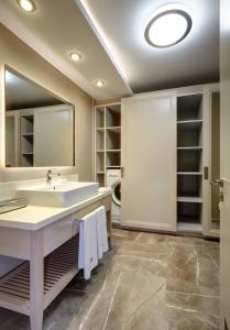 a bathroom with a sink and a mirror at Heykel Suites Otel in Konak