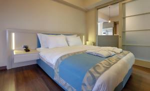 a bedroom with a large bed with pillows on it at Heykel Suites Otel in Konak