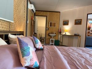 a bedroom with a bed with pillows on it at Alisa Villa, Ubon Cottage in Ban Pla Duk