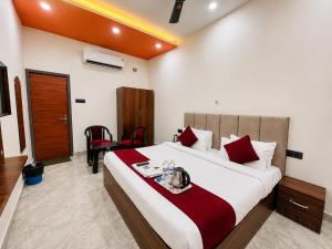 a hotel room with a large bed with red pillows at Hotel RL Ramayansh - 300 mtr From Ram Mandir Ayodhya in Ayodhya +3 photos