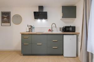 a kitchen with a sink and a refrigerator at Studio élégant en RDC, confort et simplicité in Vaires-sur-Marne