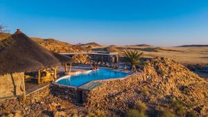 a resort with a swimming pool in the desert at Rostock Ritz Desert Lodge in Cha-re