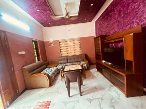 a living room with a couch and a tv at Happy Home Varkala in Varkala