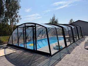a pool in a glass igloo with a swimming pool at Pogodne Domki in Darłowo