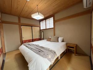 a bedroom with a large bed and a window at Tani House Tokiwa Nozawa Onsen & More in Iiyama