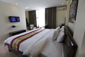 a bedroom with a large bed with a television on the wall at Hoang Ngoc Hotel in Dồng Văn