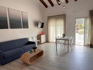 a living room with a blue couch and a table at Dune Prestige & Chalets in Bibione