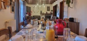 a table with glasses and a jug of orange juice at Les Chambres du Saladou in Mont-Chanson