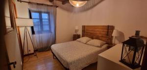 a small bedroom with a bed and a window at Les Chambres du Saladou in Mont-Chanson