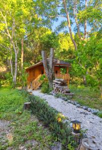 a cabin in the woods with a pathway leading to it at Air Wontu in Moyo Island