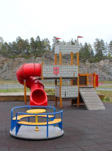 un parque infantil con un tobogán rojo en un parque en Heimat Brokelandsheia en Gjerstad