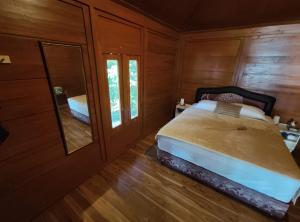 a bedroom with a large bed and a mirror at Air Wontu in Moyo Island