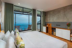 a bedroom with a large bed and a balcony at leisure Mount View in Haputale