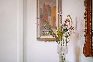 a vase with flowers in it on a table next to a mirror at Luxury Apartment Lake View in Bolsena