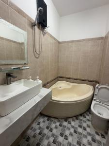 a bathroom with a tub and a sink and a toilet at TUNI Hotel in Long Bình +8 photos