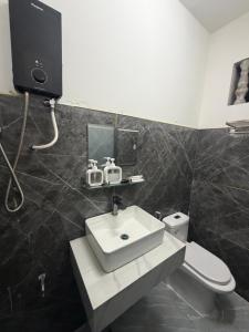 a bathroom with a white sink and a toilet at TUNI Hotel in Long Bình