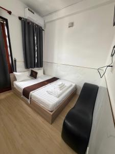 a small bedroom with a bed and a chair at TUNI Hotel in Long Bình