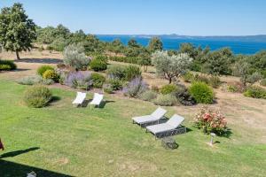 a group of white benches sitting on a grass field at Luxury Apartment Lake View in Bolsena