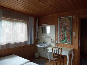 a bathroom with a sink in a wooden room at Zimmerhäusl in Schlitters