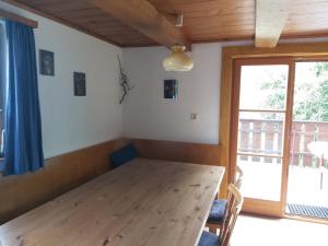 a dining room with a wooden table and a window at Zimmerhäusl in Schlitters